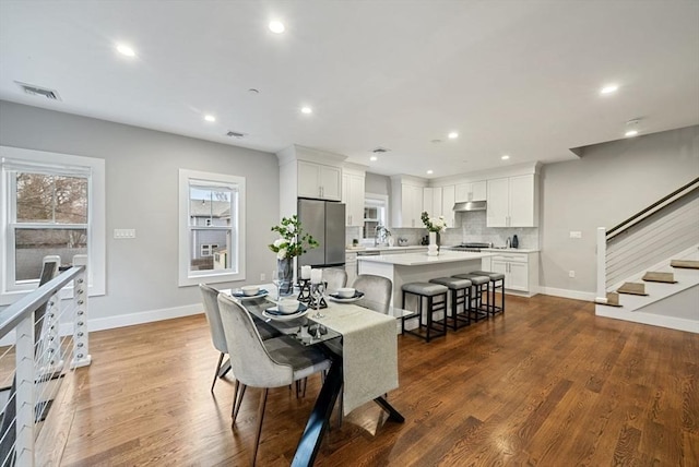 dining room featuring dark wood-type flooring and plenty of natural light