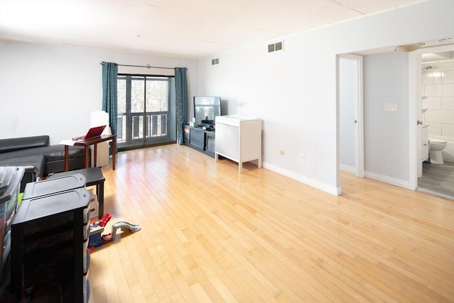 office space with visible vents, light wood-style flooring, and baseboards