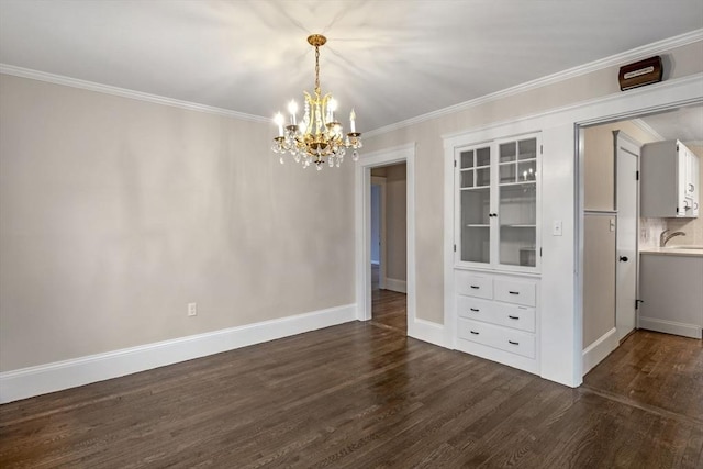 unfurnished dining area featuring dark hardwood / wood-style floors, an inviting chandelier, crown molding, and sink