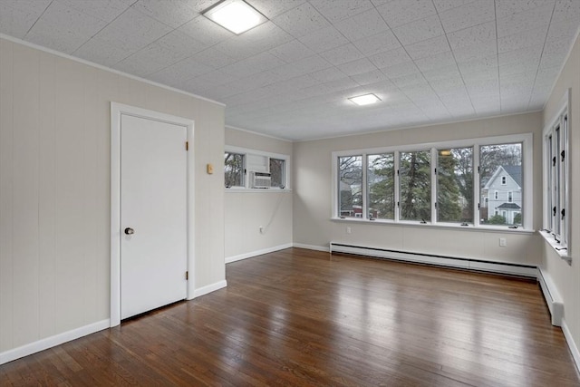 unfurnished room with dark hardwood / wood-style floors, baseboard heating, and ornamental molding