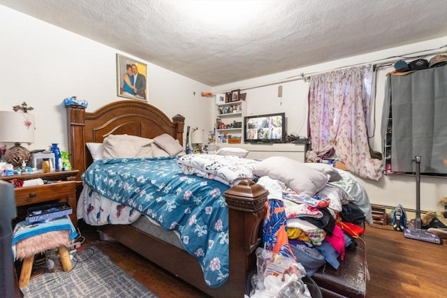 bedroom featuring a textured ceiling and wood finished floors