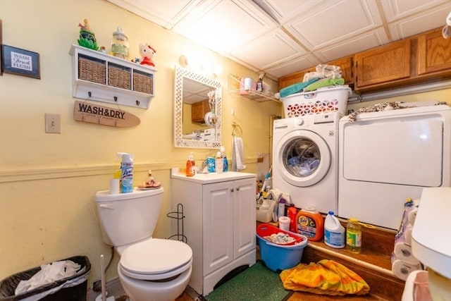 bathroom with toilet, washer and clothes dryer, and vanity