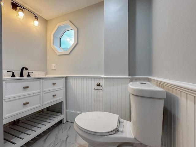 624 Western Ave, Gloucester, MA 01930 - half bathroom with marble look tile flooring, wainscoting, and vanity