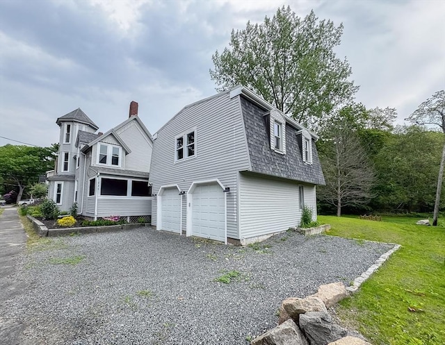 624 Western Ave, Gloucester, MA 01930 - view of side of home with a garage, a shingled roof, a gambrel roof, driveway, and a lawn