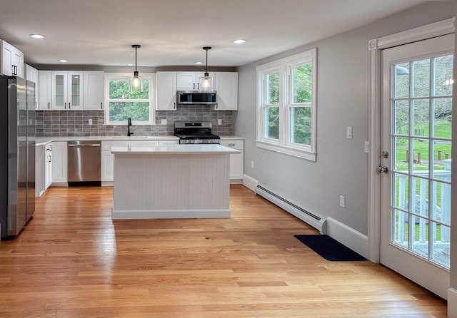624 Western Ave, Gloucester, MA 01930 - kitchen featuring stainless steel appliances, baseboard heating, light wood finished floors, backsplash, and light countertops