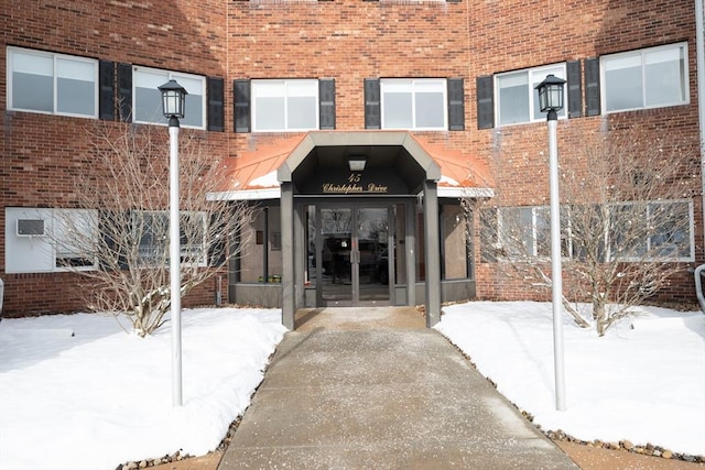 snow covered property entrance featuring french doors