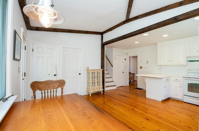 kitchen featuring white electric range oven, beam ceiling, white cabinets, light wood-style floors, and recessed lighting