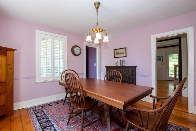 dining area featuring baseboards, an inviting chandelier, and wood finished floors