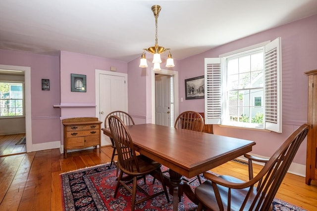 dining space with baseboards and hardwood / wood-style flooring