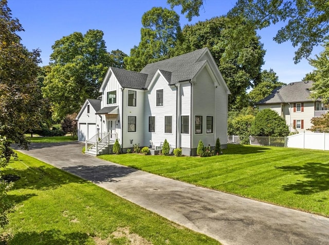 view of front facade featuring a front lawn, roof with shingles, and fence