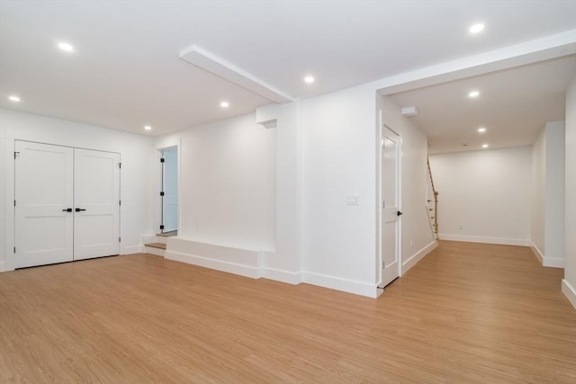 interior space featuring baseboards, light wood finished floors, stairway, and recessed lighting