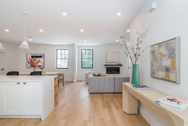 interior space featuring baseboards, light wood-type flooring, a fireplace, and recessed lighting