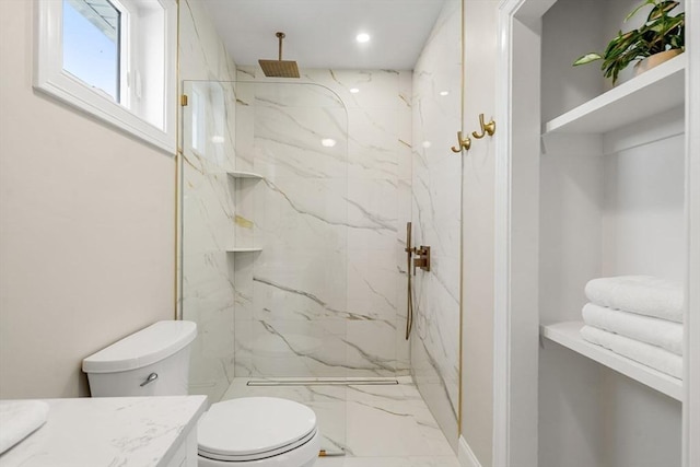 bathroom featuring tiled shower, vanity, and toilet