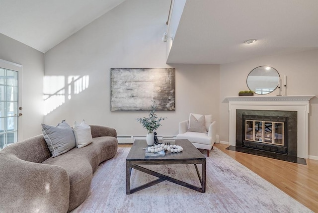 living room featuring lofted ceiling, a baseboard radiator, a fireplace with flush hearth, and wood finished floors