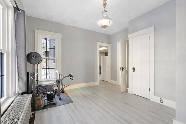 workout area featuring baseboards and wood finished floors