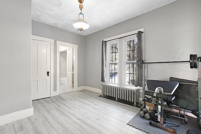 interior space featuring radiator, baseboards, and wood finished floors