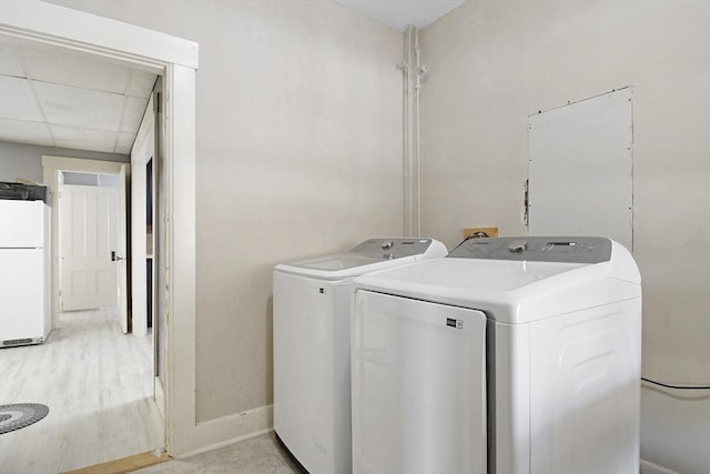 clothes washing area featuring laundry area, separate washer and dryer, and baseboards