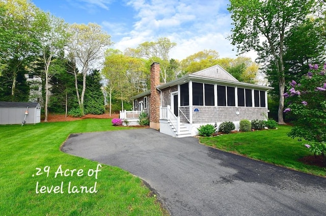 173 Standish Rd, Bourne, MA 02562 - view of front facade with a sunroom, a chimney, and a front yard