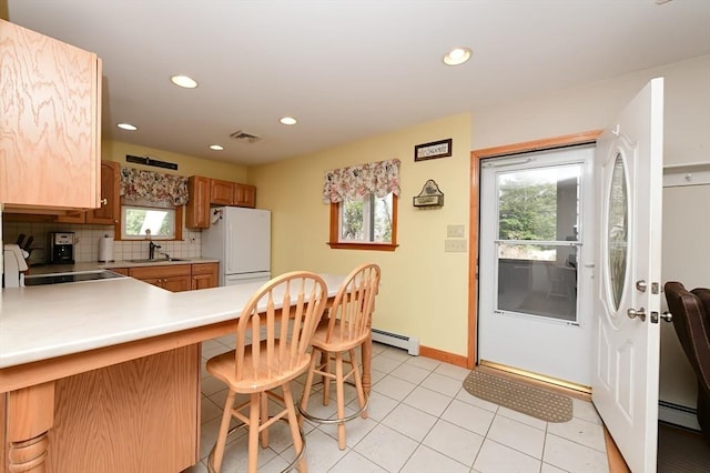 173 Standish Rd, Bourne, MA 02562 - kitchen featuring freestanding refrigerator, a baseboard heating unit, a peninsula, light countertops, and backsplash