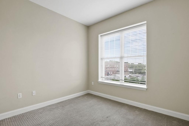 carpeted empty room with baseboards