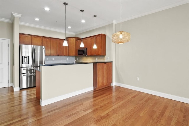 kitchen featuring stainless steel appliances, brown cabinets, tasteful backsplash, crown molding, and pendant lighting