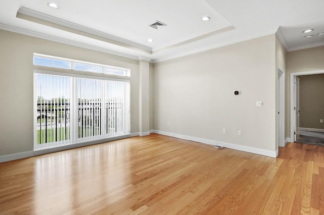 empty room featuring crown molding, plenty of natural light, light wood-style floors, recessed lighting, and baseboards