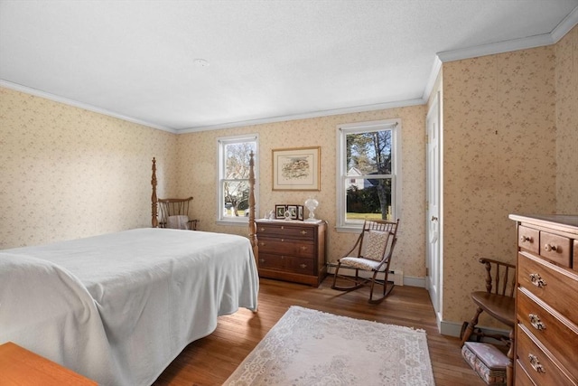 bedroom featuring wood-type flooring, baseboard heating, and ornamental molding