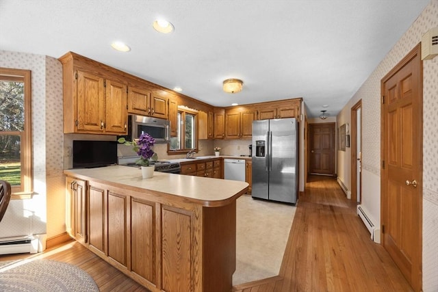 kitchen featuring kitchen peninsula, stainless steel appliances, a baseboard radiator, and light hardwood / wood-style floors