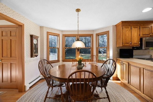 dining space featuring light hardwood / wood-style flooring and a baseboard heating unit