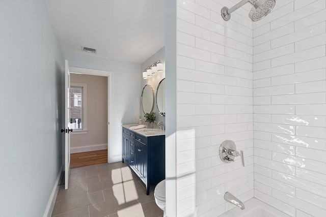 full bathroom with tile patterned flooring, toilet, vanity, and tiled shower / bath