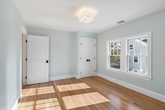 unfurnished bedroom with light wood-type flooring and a closet