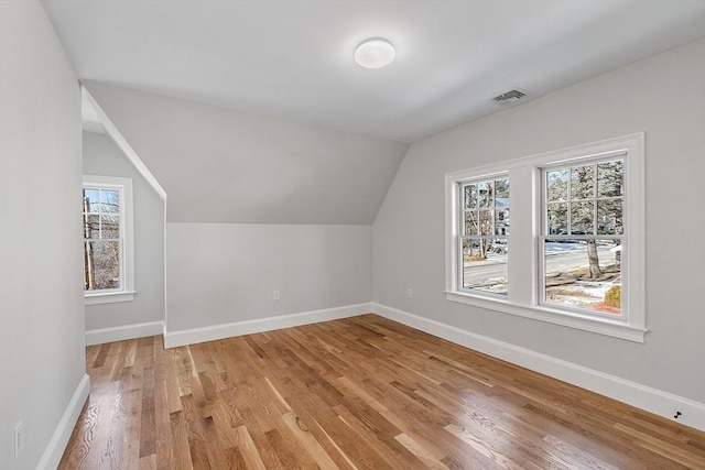 additional living space with lofted ceiling and light hardwood / wood-style flooring