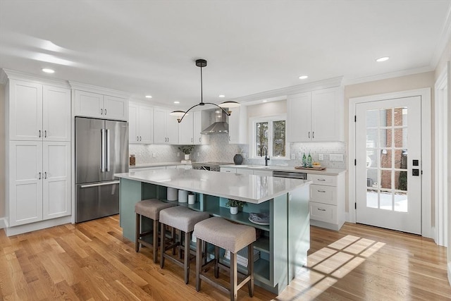 kitchen with white cabinets, stainless steel appliances, a kitchen island, and hanging light fixtures