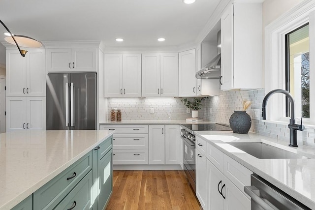 kitchen with green cabinetry, tasteful backsplash, white cabinetry, appliances with stainless steel finishes, and sink