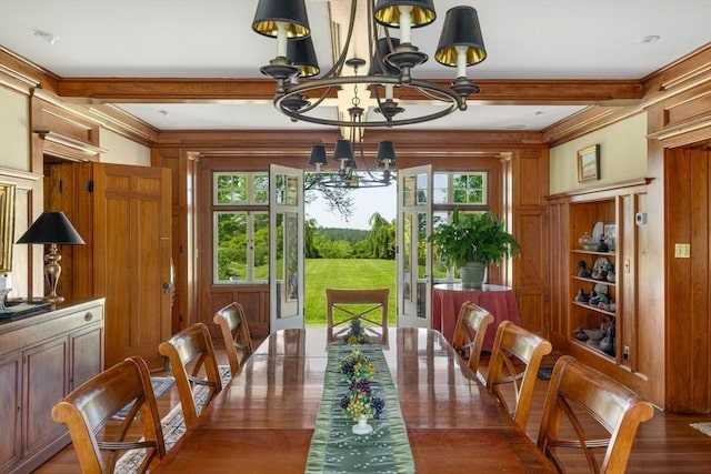 dining space with an inviting chandelier, ornamental molding, a wealth of natural light, and wood finished floors