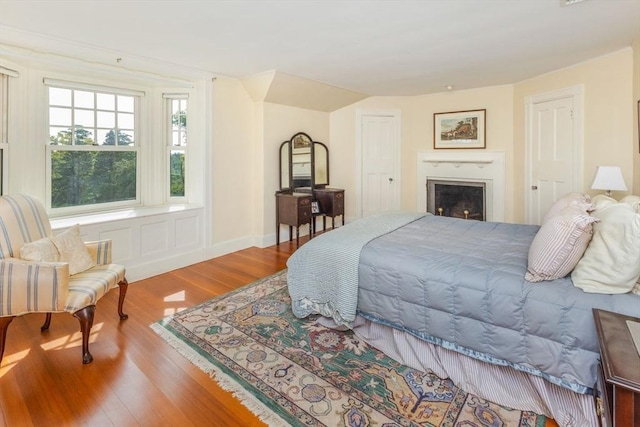 bedroom with a fireplace and wood finished floors