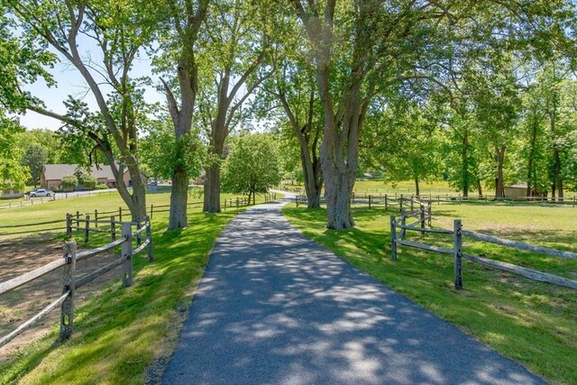 view of community with fence and a lawn