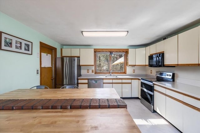 kitchen featuring a sink, light countertops, white cabinetry, and stainless steel appliances