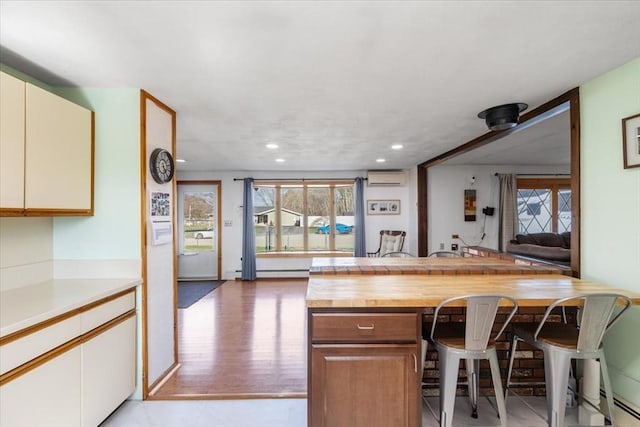 kitchen featuring butcher block countertops, a wall unit AC, and recessed lighting