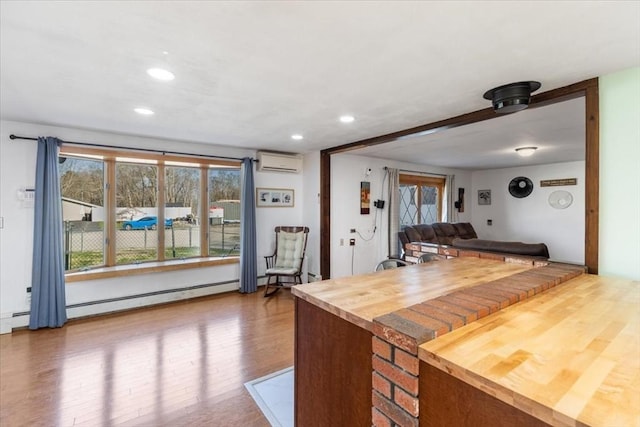 kitchen featuring butcher block countertops, baseboard heating, recessed lighting, a wall unit AC, and wood finished floors