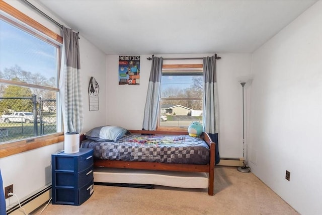bedroom with baseboard heating, light colored carpet, and multiple windows