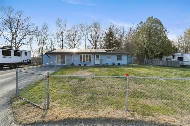 ranch-style home with aphalt driveway, a front lawn, and a fenced front yard