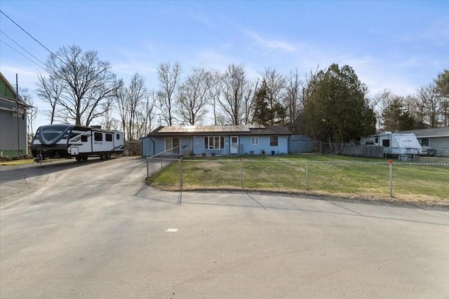 ranch-style home featuring a fenced front yard, concrete driveway, and a front lawn