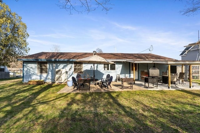 rear view of house featuring a patio area and a lawn