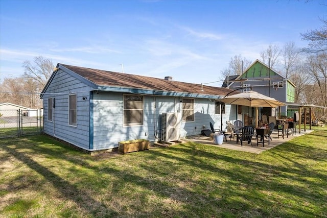 back of house featuring a patio, a yard, fence, and a gate
