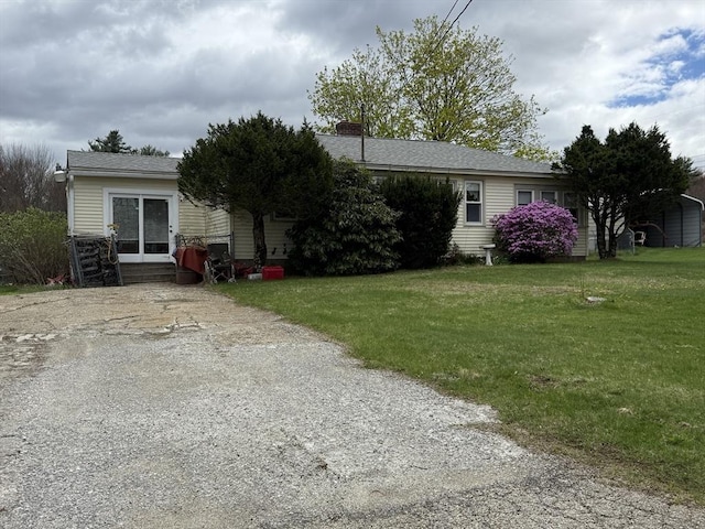 view of front facade featuring a chimney and a front yard
