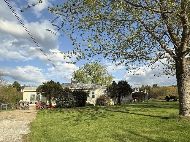 view of front facade with a detached carport and a front yard