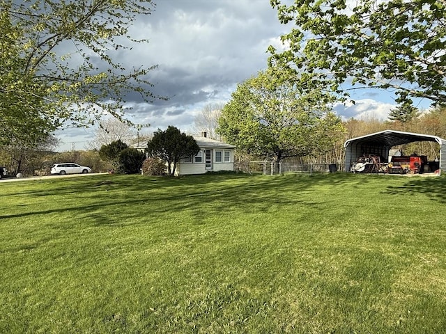 view of yard featuring fence and a detached carport