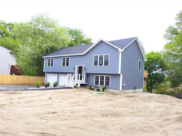 back of property featuring a garage and fence