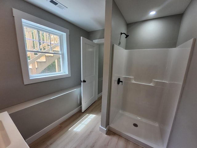 bathroom with wood finished floors, a shower stall, baseboards, and recessed lighting